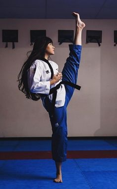 a woman standing on one leg in a karate position