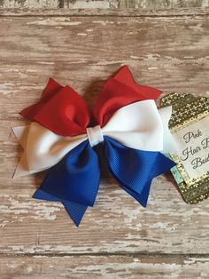 a red, white and blue bow with a happy birthday tag on it sitting on top of a wooden table