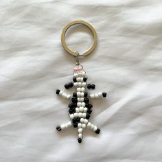 a keychain made to look like a lizard with black and white beads on it