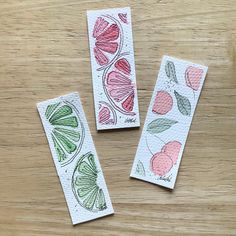 three handmade bookmarks sitting on top of a wooden table