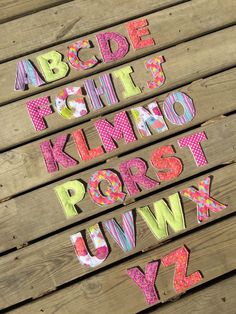 the letters are made out of wood and have different patterns on them, including polka dots