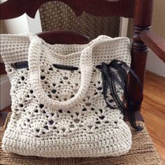 a crocheted purse sitting on top of a wooden chair