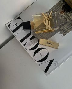 a bottle of perfume sitting on top of a magazine