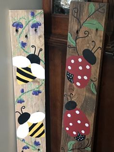 two wooden boards with painted ladybugs and bees on them are sitting next to each other