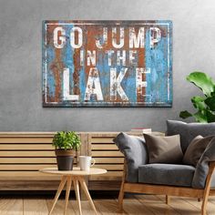 an old metal sign that says go jump in the lake on a wall above a wooden bench