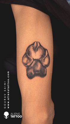 a dog paw tattoo on the right thigh and leg, it is black and white