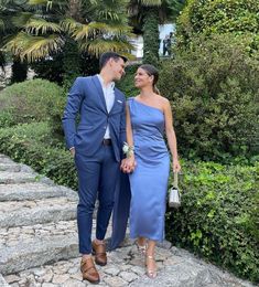 a man and woman in formal wear walking down some steps