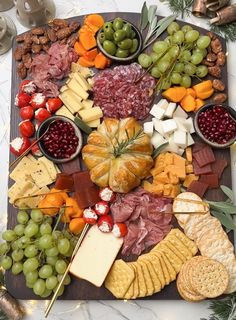 an assortment of cheeses, meats and vegetables on a platter with crackers