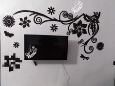 a television mounted to the side of a wall with black and white flowers on it