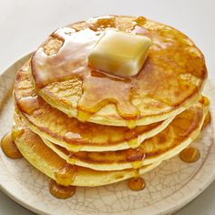 a stack of pancakes covered in syrup and butter