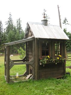 a chicken coop with flowers in the window