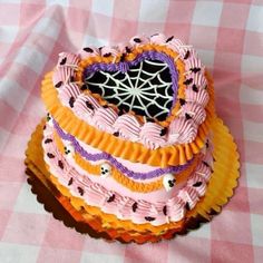 a heart shaped cake sitting on top of a pink and white tablecloth covered table