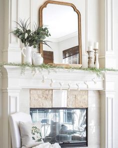 a living room with a fire place and mirror above the fireplace in front of it