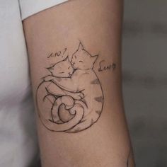 a woman with a tattoo on her arm holding a cat in the shape of a heart