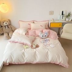 there is a teddy bear on the bed with pink comforter and pillowcases