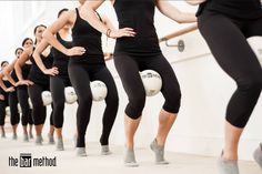 a group of women standing next to each other in front of a white wall with balls on it