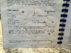 an old recipe book sitting on top of a counter next to a paper clipping