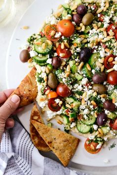 a white plate topped with cucumber, olives, and feta cheese