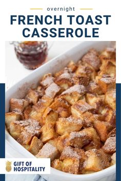 french toast casserole in a white dish with powdered sugar on the top