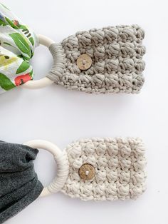 two crocheted headbands with buttons on them, one in grey and the other in white