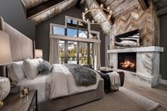 a large bedroom with a fireplace in the corner and lots of pillows on the bed