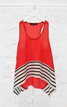 a red top hanging on a white wall with black and white stripes in the bottom