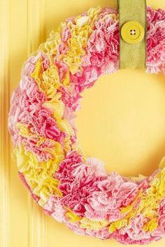 a yellow door with a pink and yellow wreath on it