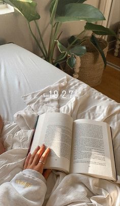 a person laying in bed reading a book