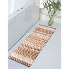 a white bath tub sitting next to a wooden rug