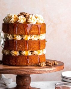 a cake with icing and nuts on a wooden stand