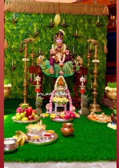 an idol sitting on top of a lush green field next to other foods and decorations