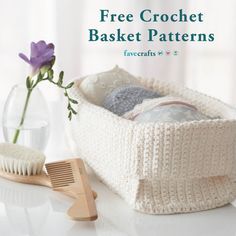 a knitted basket next to a vase with flowers in it and a brush on the table