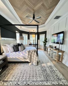 the bedroom is decorated in black and white with a canopy bed that has pillows on it