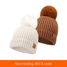 two hats with pom - poms are shown on an orange and white background