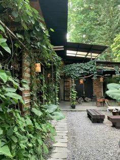 an outdoor area with benches and plants growing on the walls