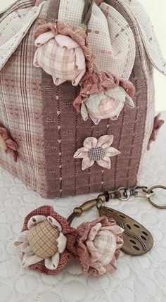 a purse with flowers on it and a keychain hanging from the front end