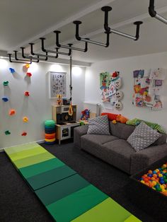 a play room with toys and games on the walls, carpeted flooring and colorful rugs