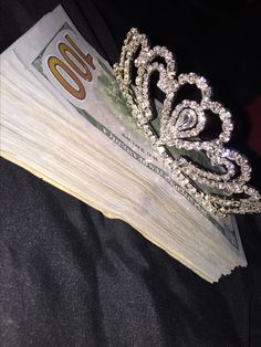 a stack of money with a tiara on top