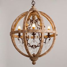 a wooden chandelier hanging from the ceiling with three candles in it and one light on