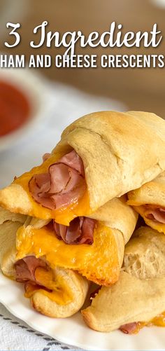 two ham and cheese pastries stacked on top of each other with sauce in the background