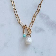 14k gold plated paperclip chain necklace with a toggle clasp and a plain pearl dangling in the middle. Necklace is 14 inches in length. Available with or without a dainty turquoise gem attached. Beach 2024, Beachy Necklace, Turquoise Gem, Dainty Chain Necklace, Paperclip Chain Necklace, Beach Necklace, Small Necklace, Beach Necklaces, Jewelry Beach