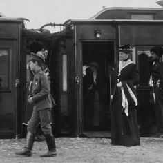 an old black and white photo of people getting onto train cars in the early 1900's