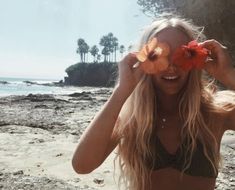 a woman with flowers in her hair on the beach