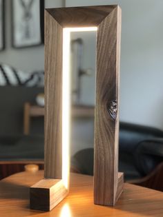 the light is shining through an open wooden frame on top of a table with a mirror in front of it