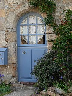 a blue door is in front of a stone building