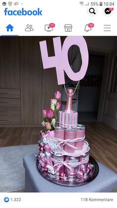 a cake made to look like the number 40 with pink candles and flowers on top