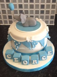 a blue and white cake with an elephant on top that says george the elephant in blocks