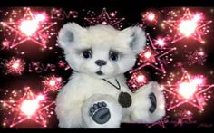 a white teddy bear sitting in front of fireworks