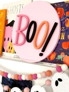 there is a sign that says boo on it and some books in front of it