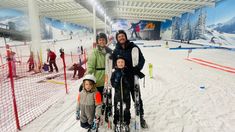 three people and two children standing in the snow